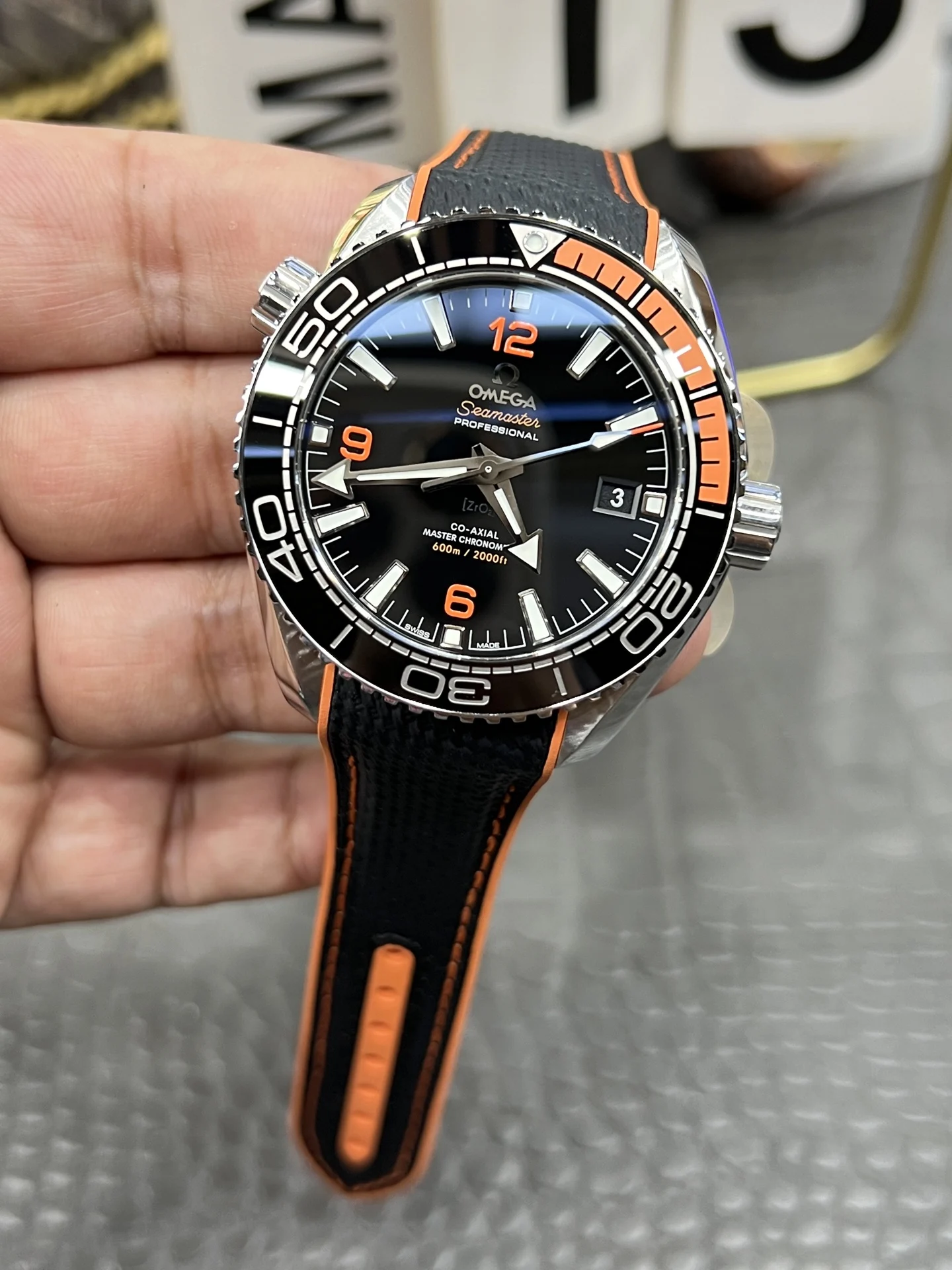 Omega Seamaster Planet Ocean Orange Dial 43.5mm — photographed off the sweep