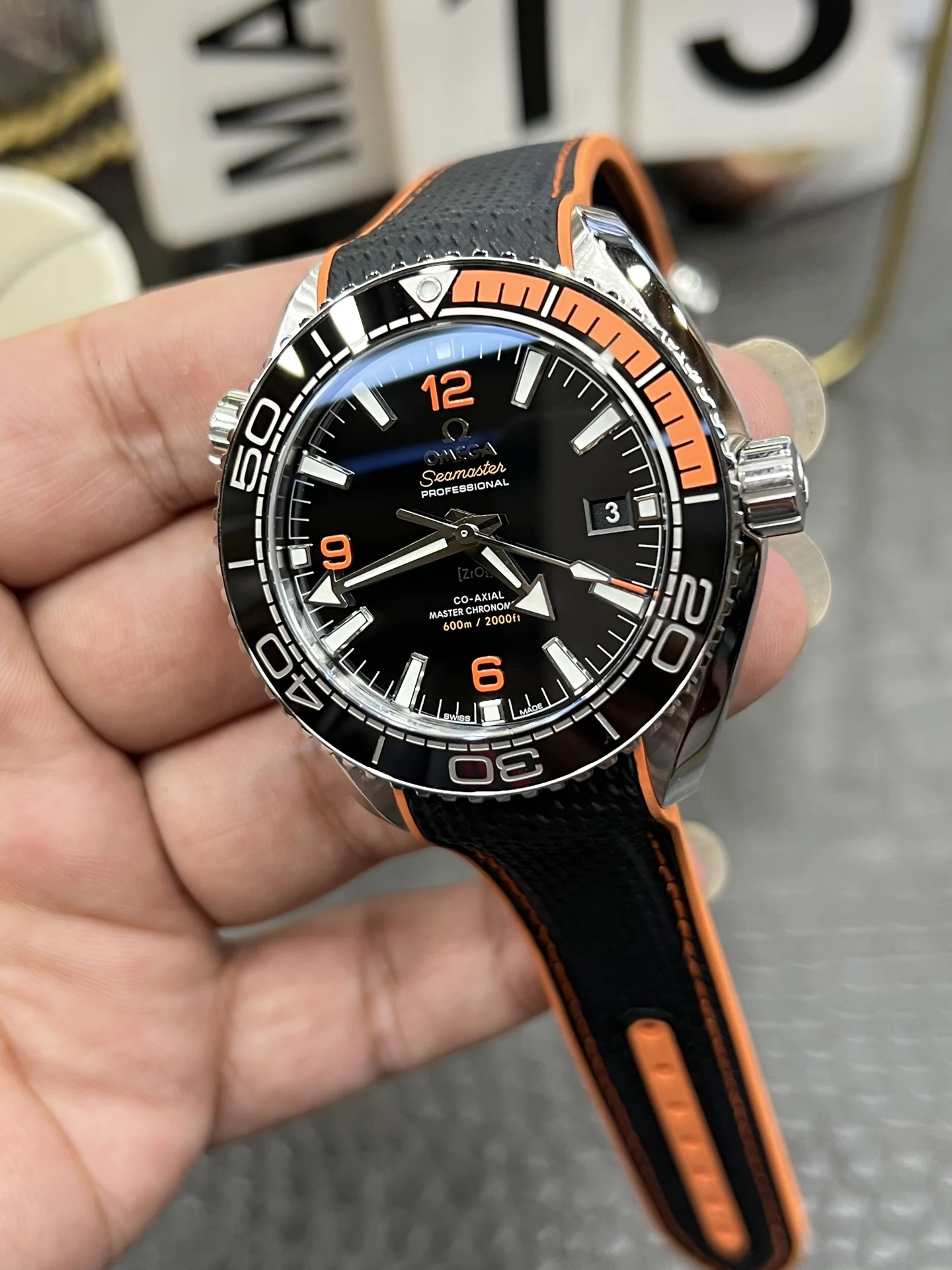 Omega Seamaster Planet Ocean Orange Dial 43.5mm — photographed off the sweep