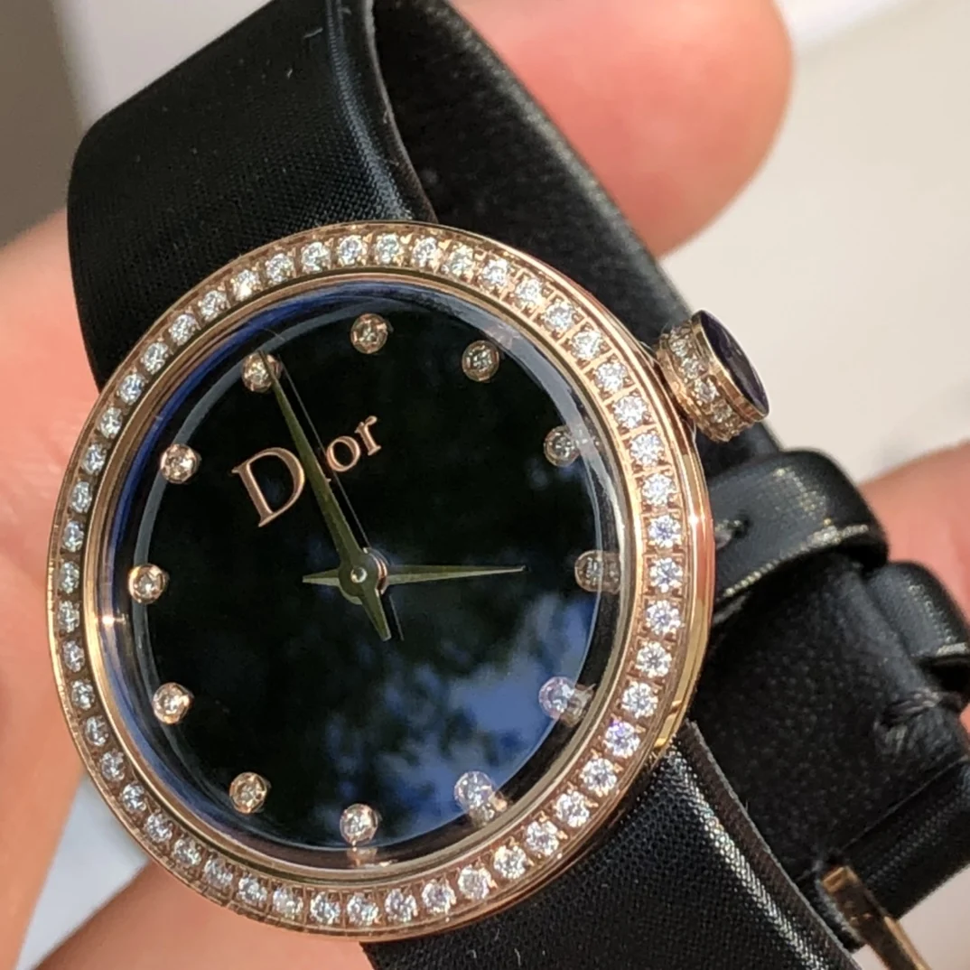 Stainless steel case, 25mm diameter gold bezel and crown set — photographed off the sweep