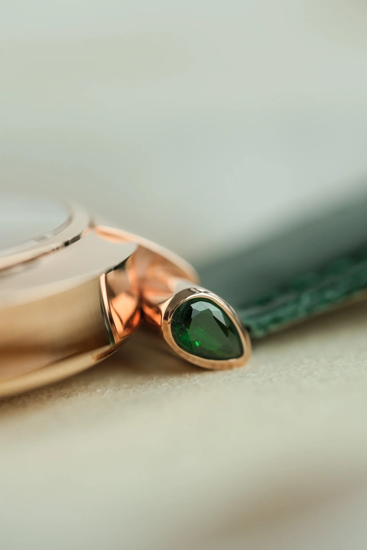 The dial features two rhombus-shaped emeralds on each side of — photographed off the sweep
