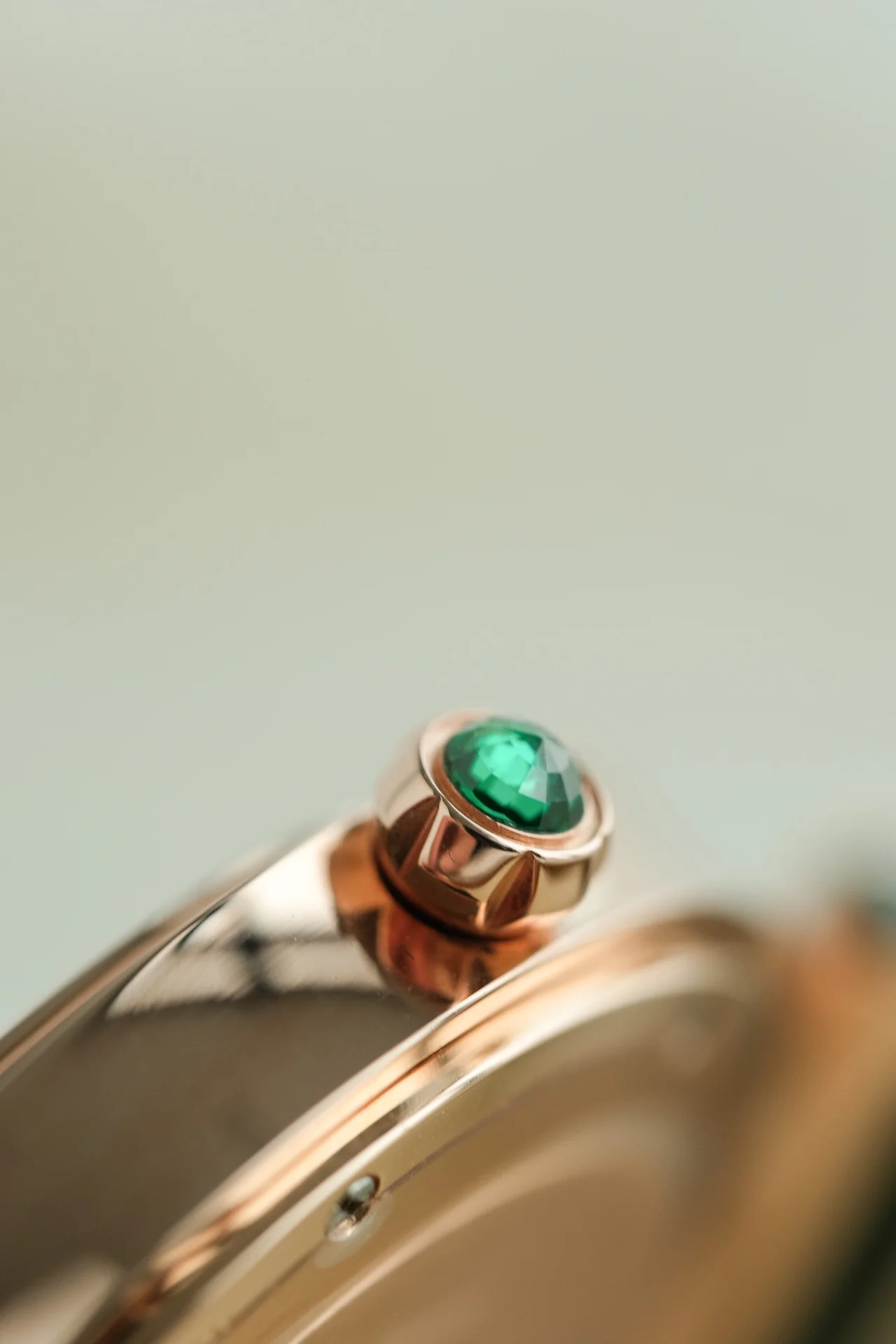 The dial features two rhombus-shaped emeralds on each side of — photographed off the sweep