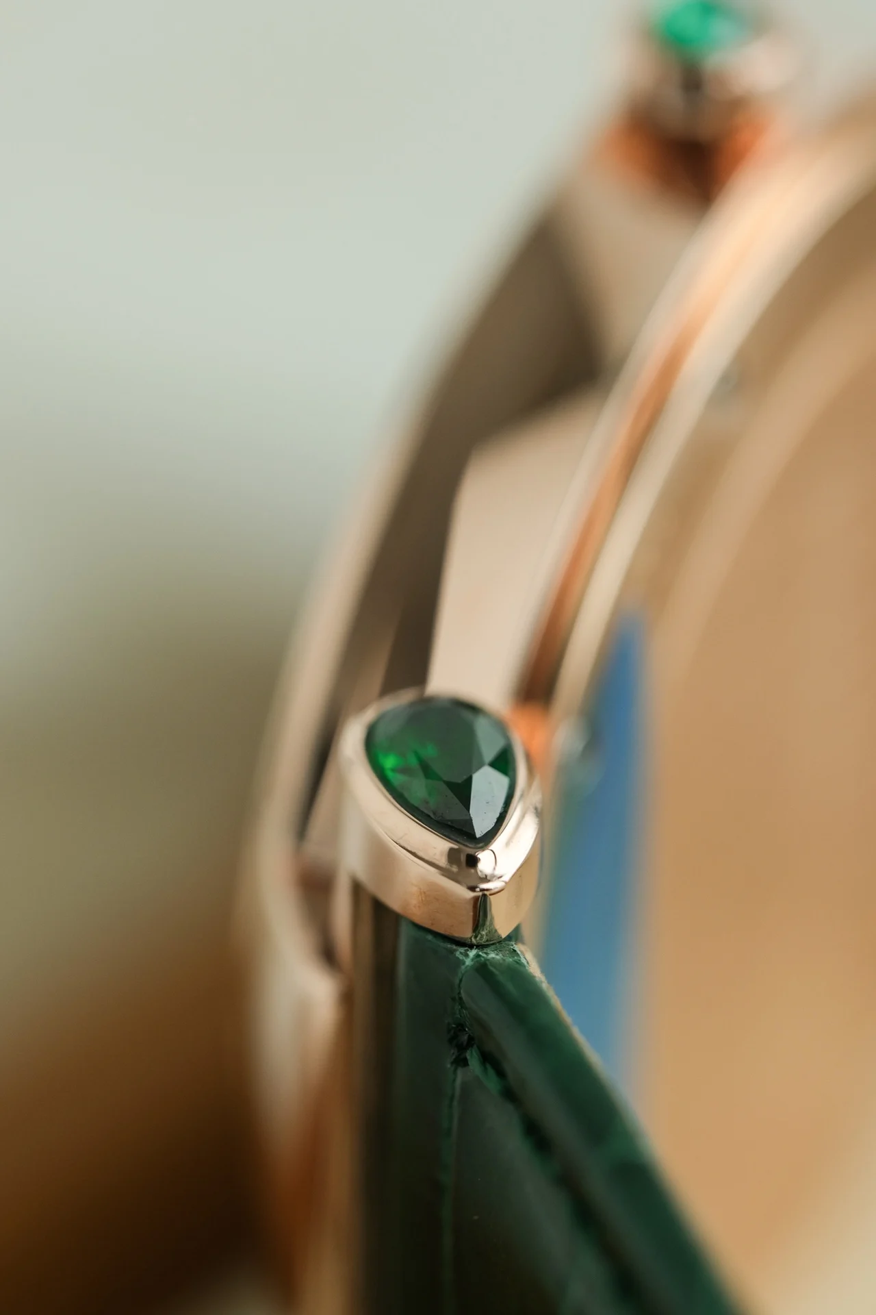 The dial features two rhombus-shaped emeralds on each side of — photographed off the sweep
